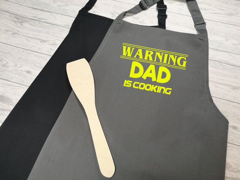 Personalised adult Warning Dad is cooking any name apron in grey or black